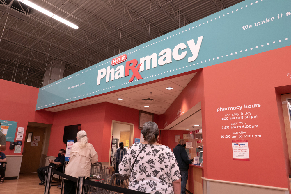 San Antonio, TX. USA - April 10, 2021: People forming a line waiting to get a vaccine and buying medicine at the pharmacy inside HEB shopping center