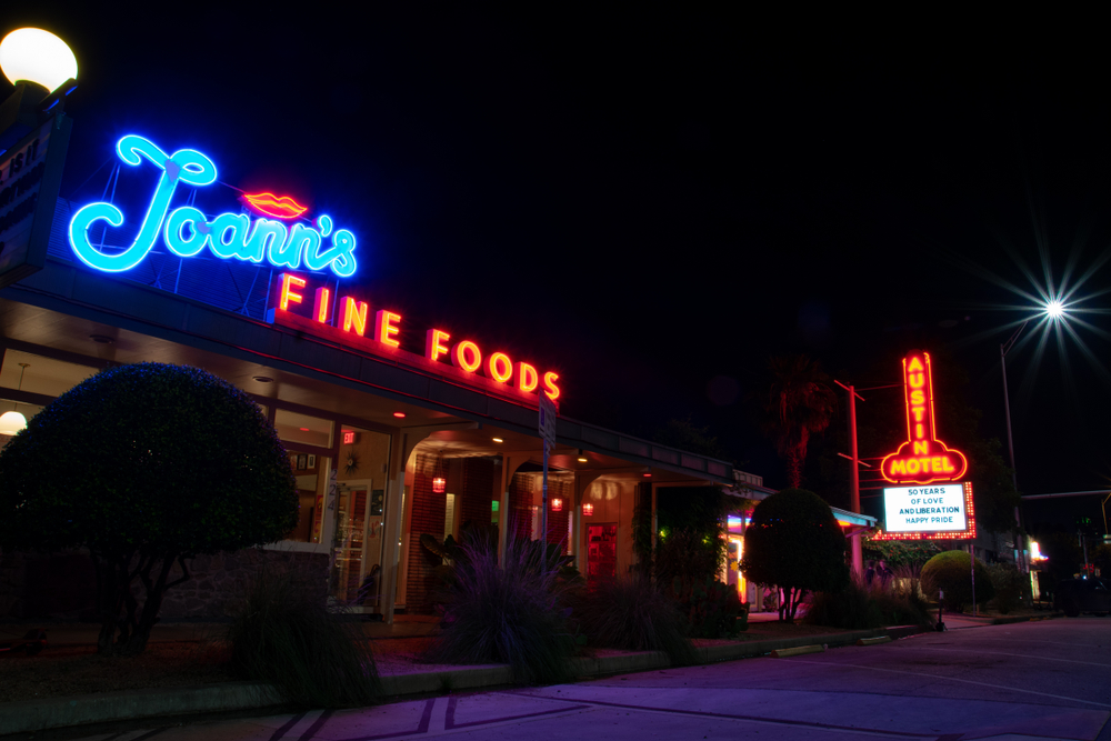 Austin, Texas / USA - June 8, 2019: An image of Joan's Fine Foods along with the iconic, Austin Motel on Austin's South Congress Avenue at night. 